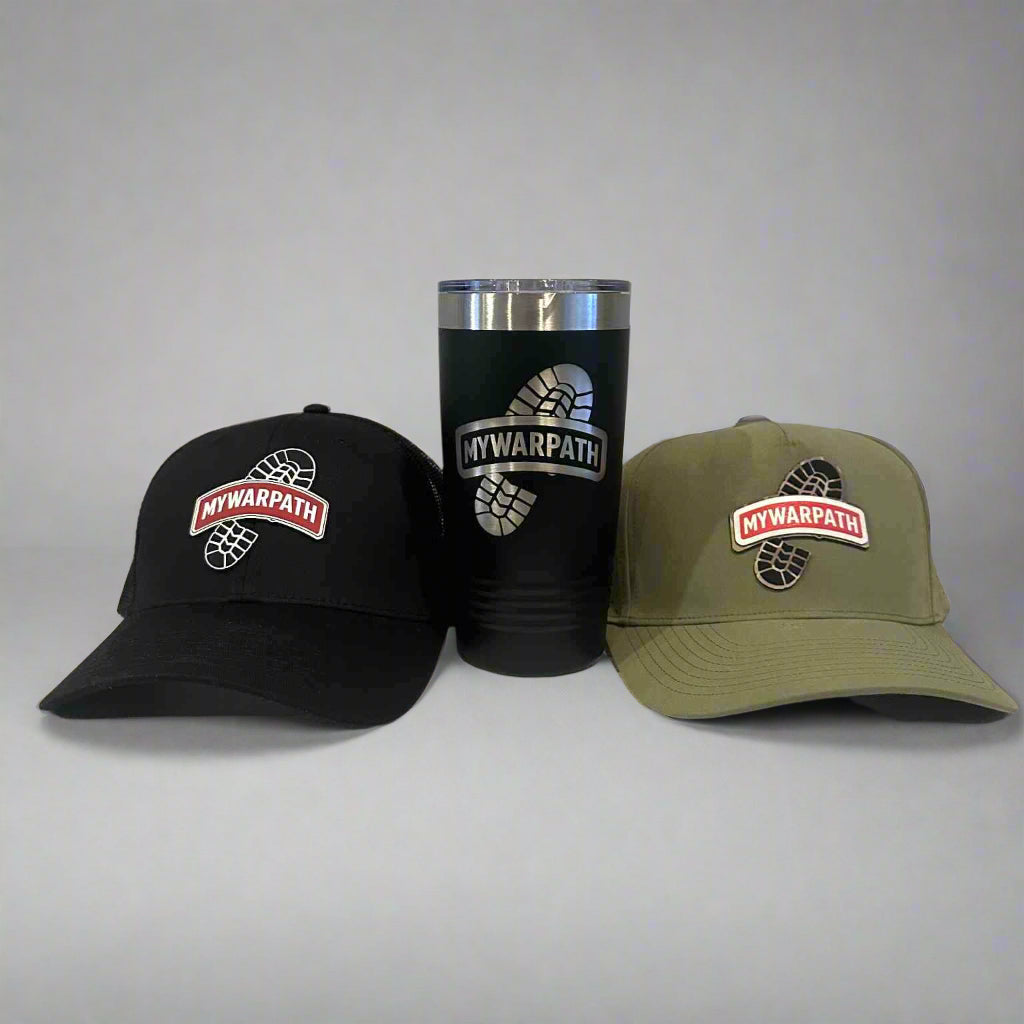 Two hats and a tumbler with a logo on a wooden surface and gray background